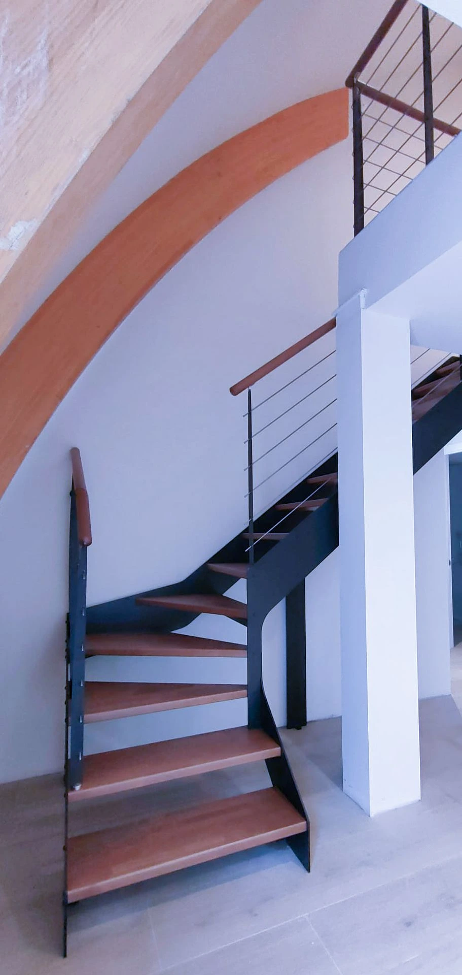 Escalera metálica con peldaños de madera en vivienda en Andorra