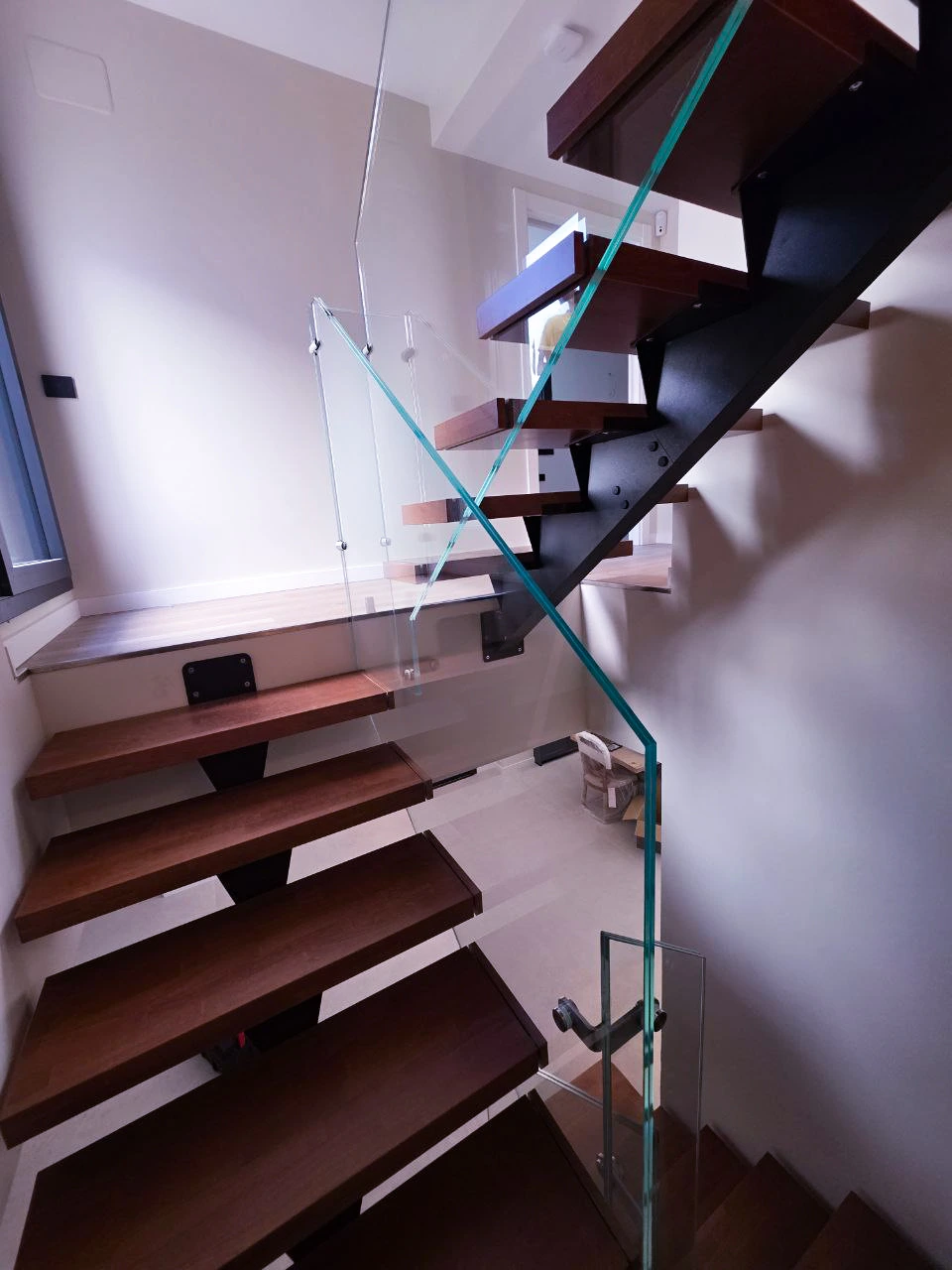 Escalera interior con zanca central metálica y peldaños de madera natural