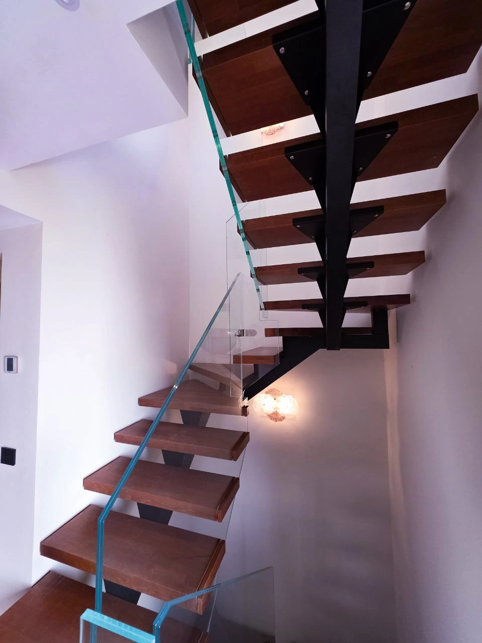 Instalación de escalera moderna con cristal y estructura metálica en vivienda residencial