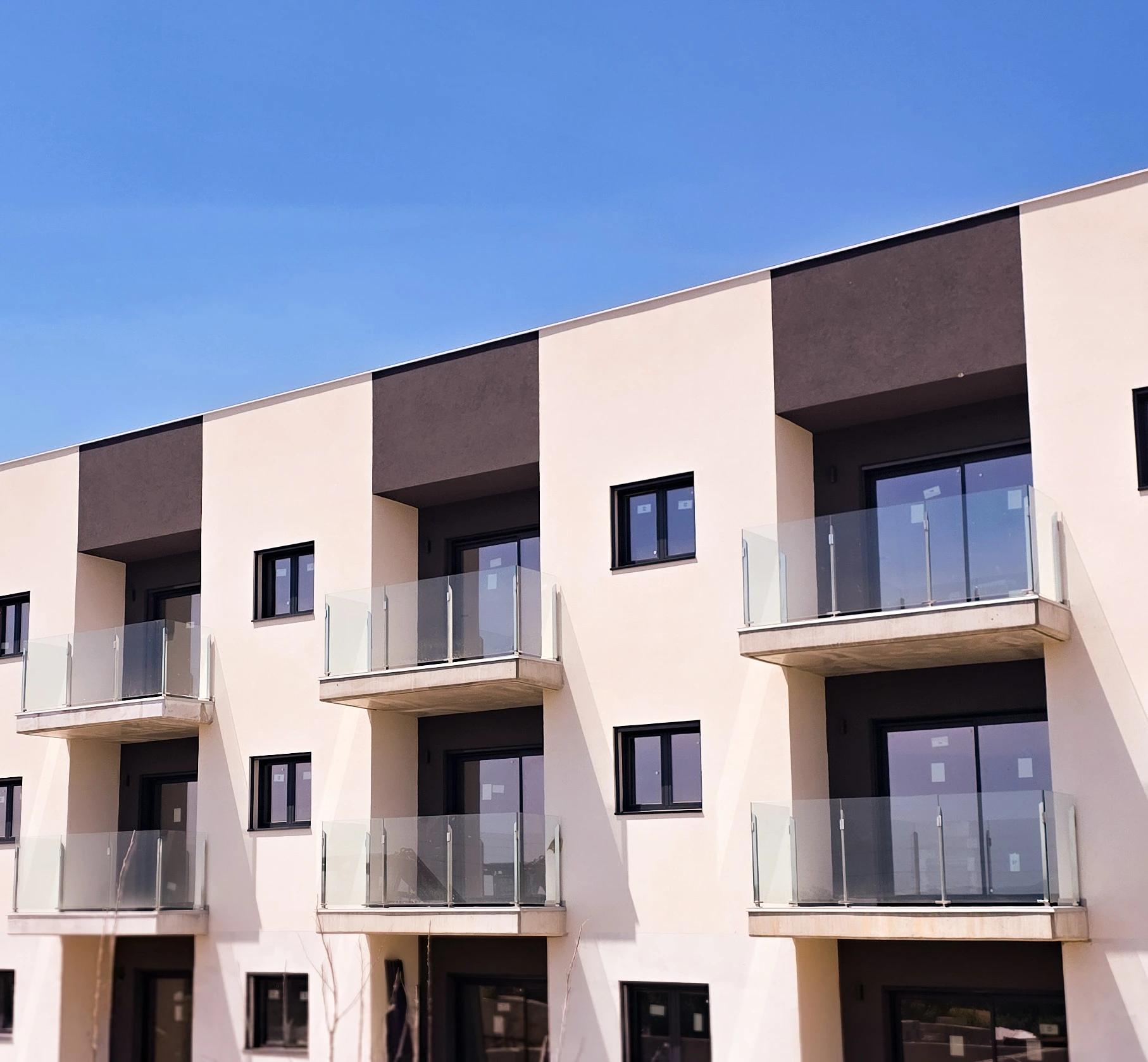 Detalle de balcones con pilares inoxidables y vidrio laminado