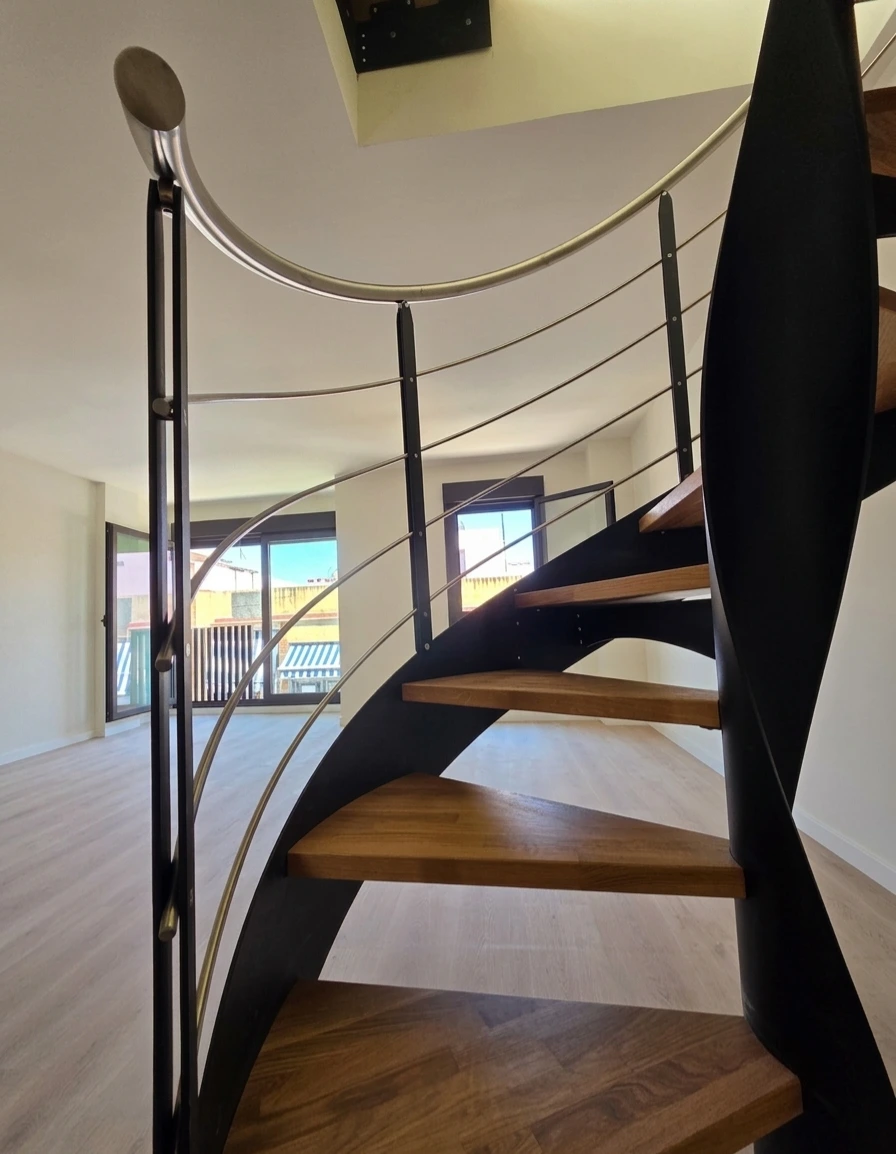 Escalera helicoidal interior con acabado blanco y peldaños de madera natural