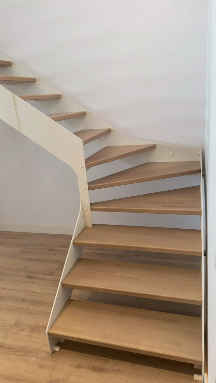 Escalera interior de estructura metálica blanca y peldaños de madera