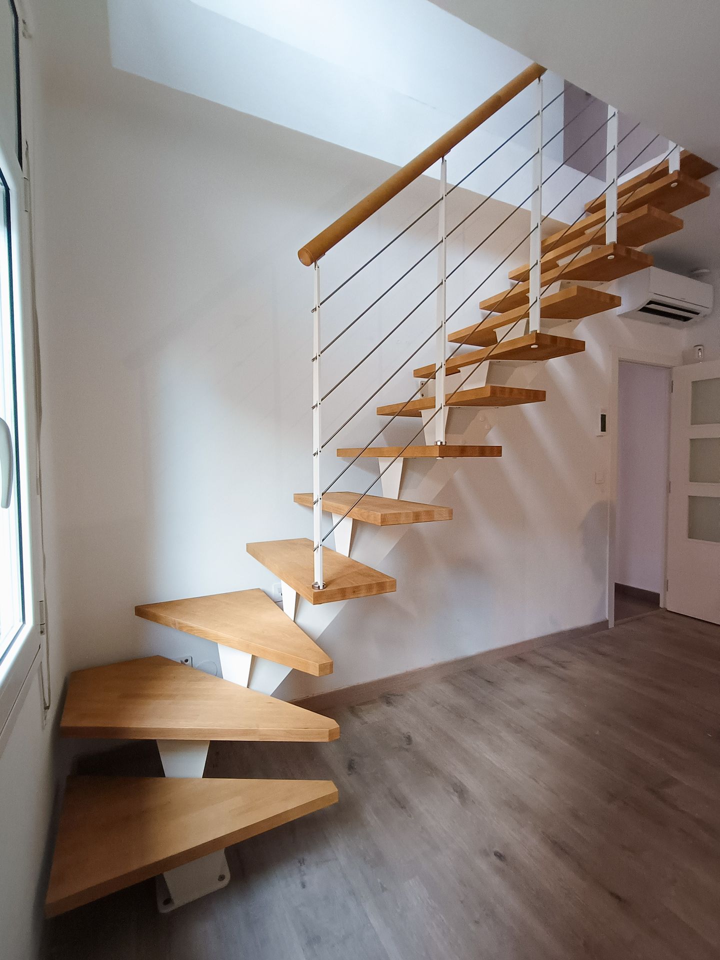 escalera metálica con peldaños de madera en vivienda moderna