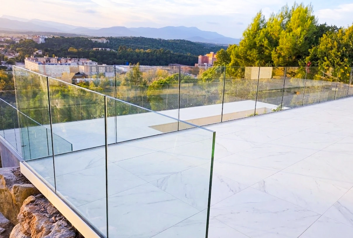 Barandillas de cristal con guía de aluminio lateral en terraza de vivienda en Girona