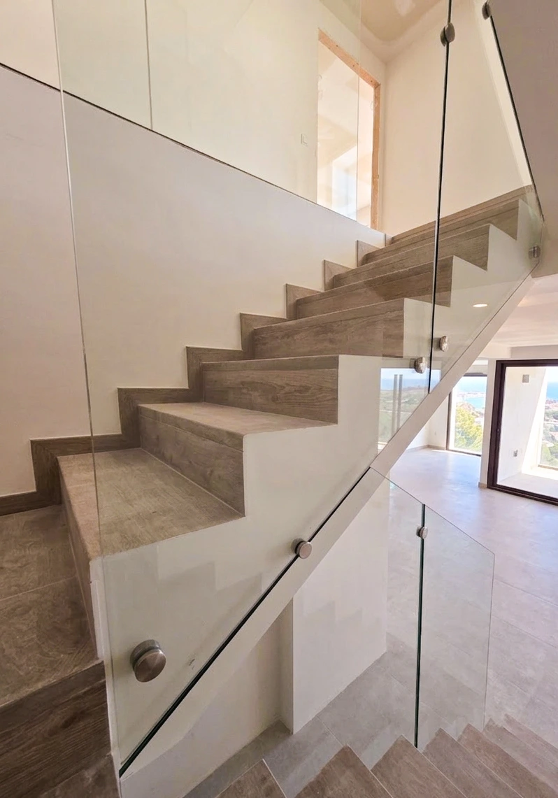 barandilla de cristal con botones en escalera interior de vivienda