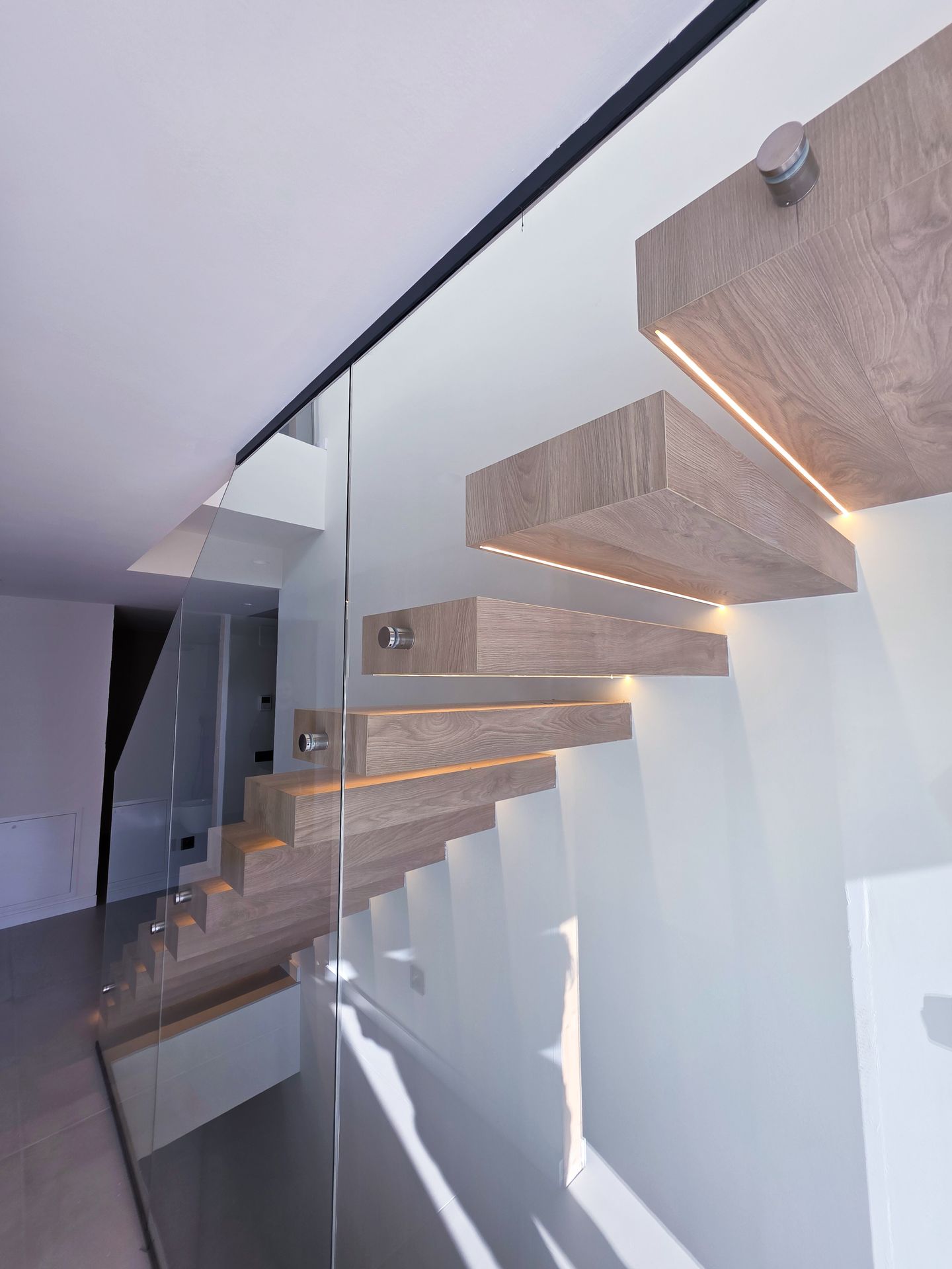 barandilla de cristal en escalera interior con botones de acero inoxidable
