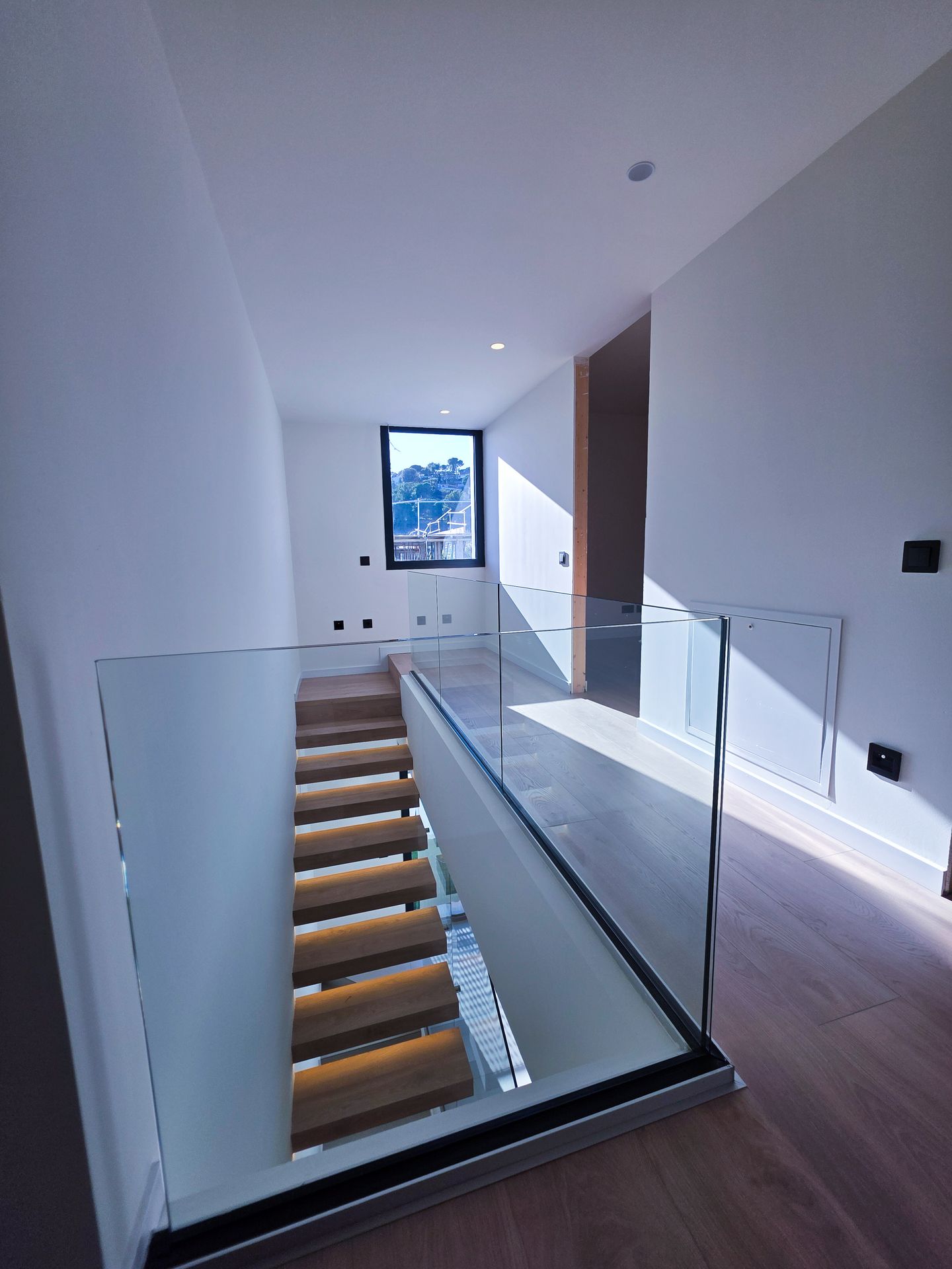 detalle de fijación de barandilla de cristal en escalera interior