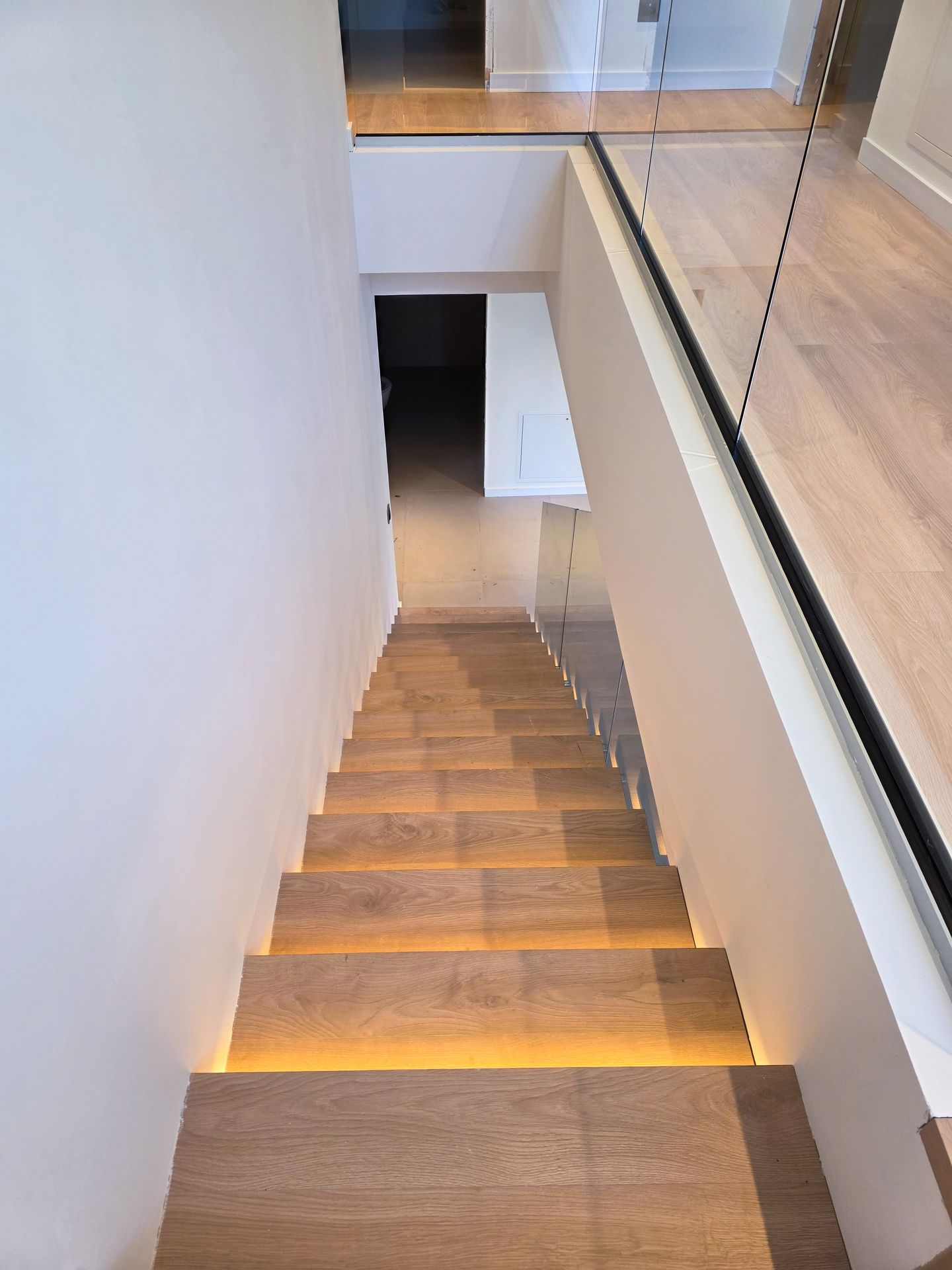 detalle de fijación de barandilla de cristal en escalera interior